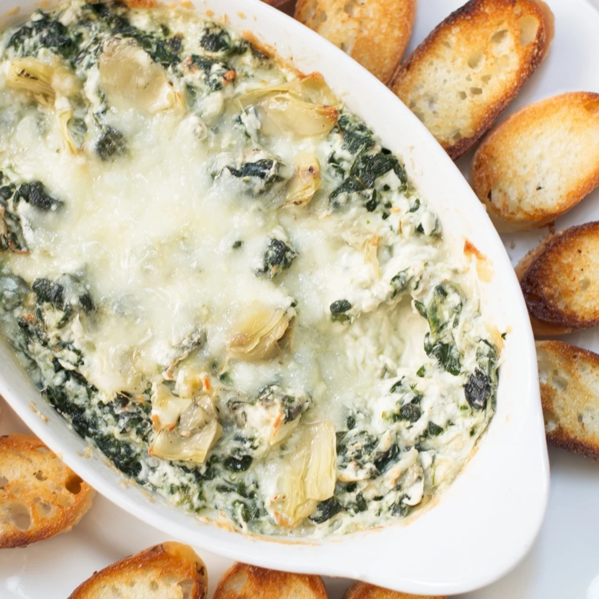 A close-up of Spinach Artichoke Dip, rich and cheesy, perfect for a cozy appetizer.