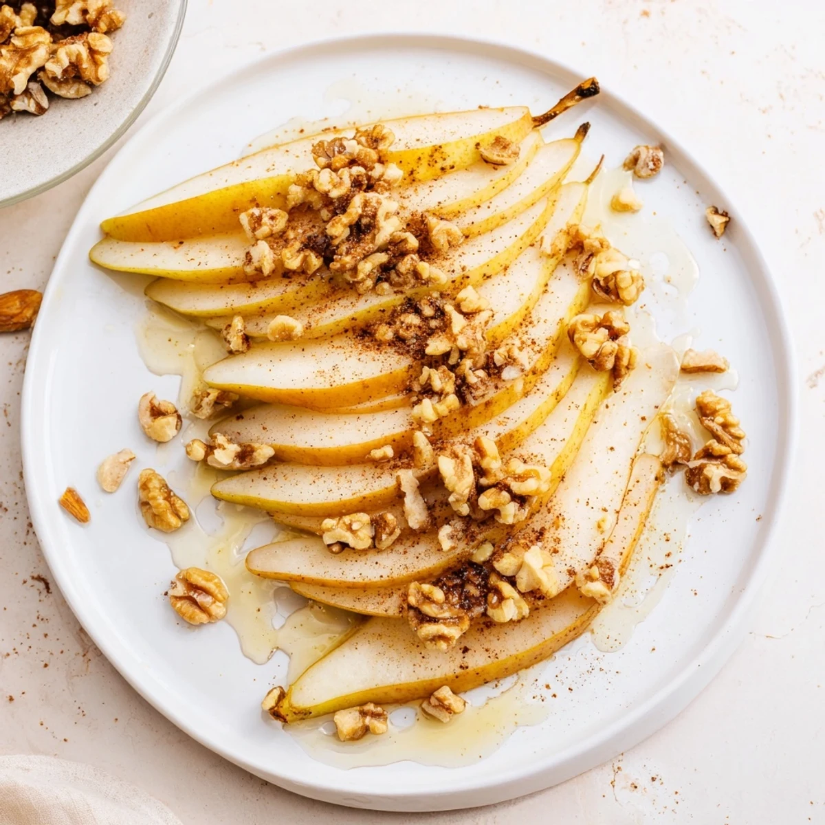 Plate of juicy pear slices glistening with a honey drizzle ready to enjoy as a sweet snack.