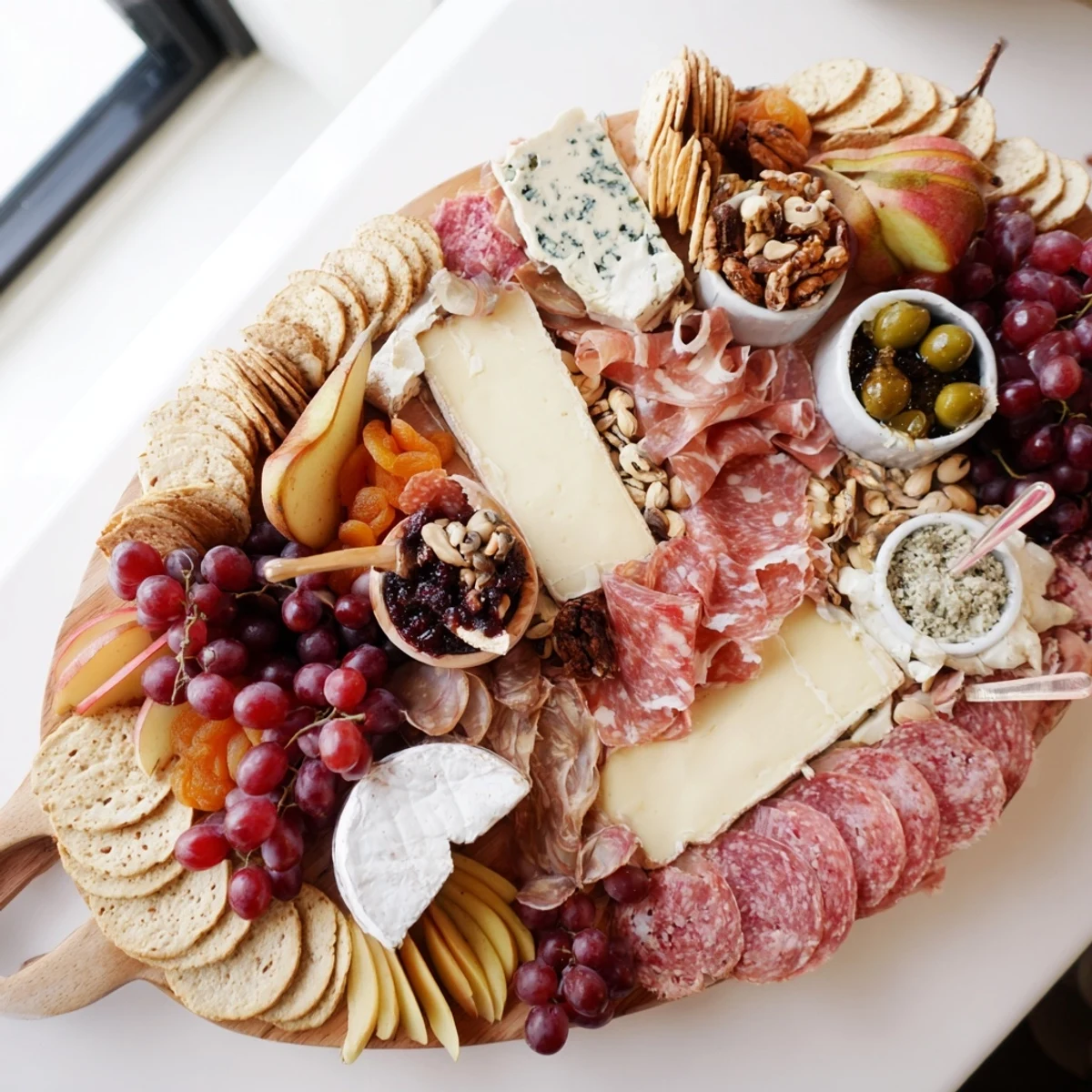 This Elegant Gilded Edge appetizer showcases a circular arrangement of cheeses, meats, and fruit around the board's edge.