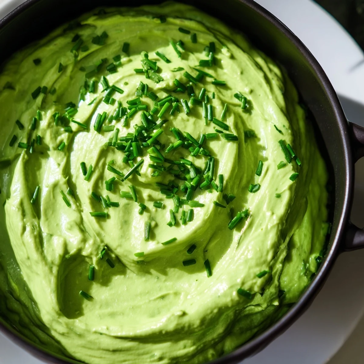Vibrant Witch's Brew Cauldron appetizer, a spooky green dip, encircled by dark, smoky-looking garnishes.
