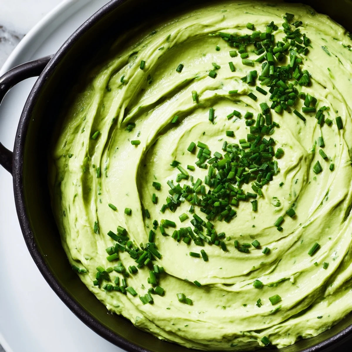 Delicious Witch's Brew Cauldron, a bubbling green dip in a black cauldron, ready for dipping on a platter.