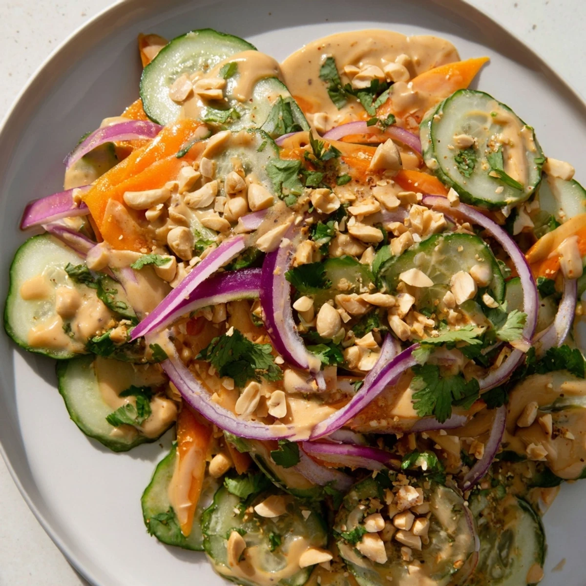 A bowl overflowing with Thai-Style Peanut Cucumber Salad, featuring crisp cucumbers and a tangy peanut sauce.
