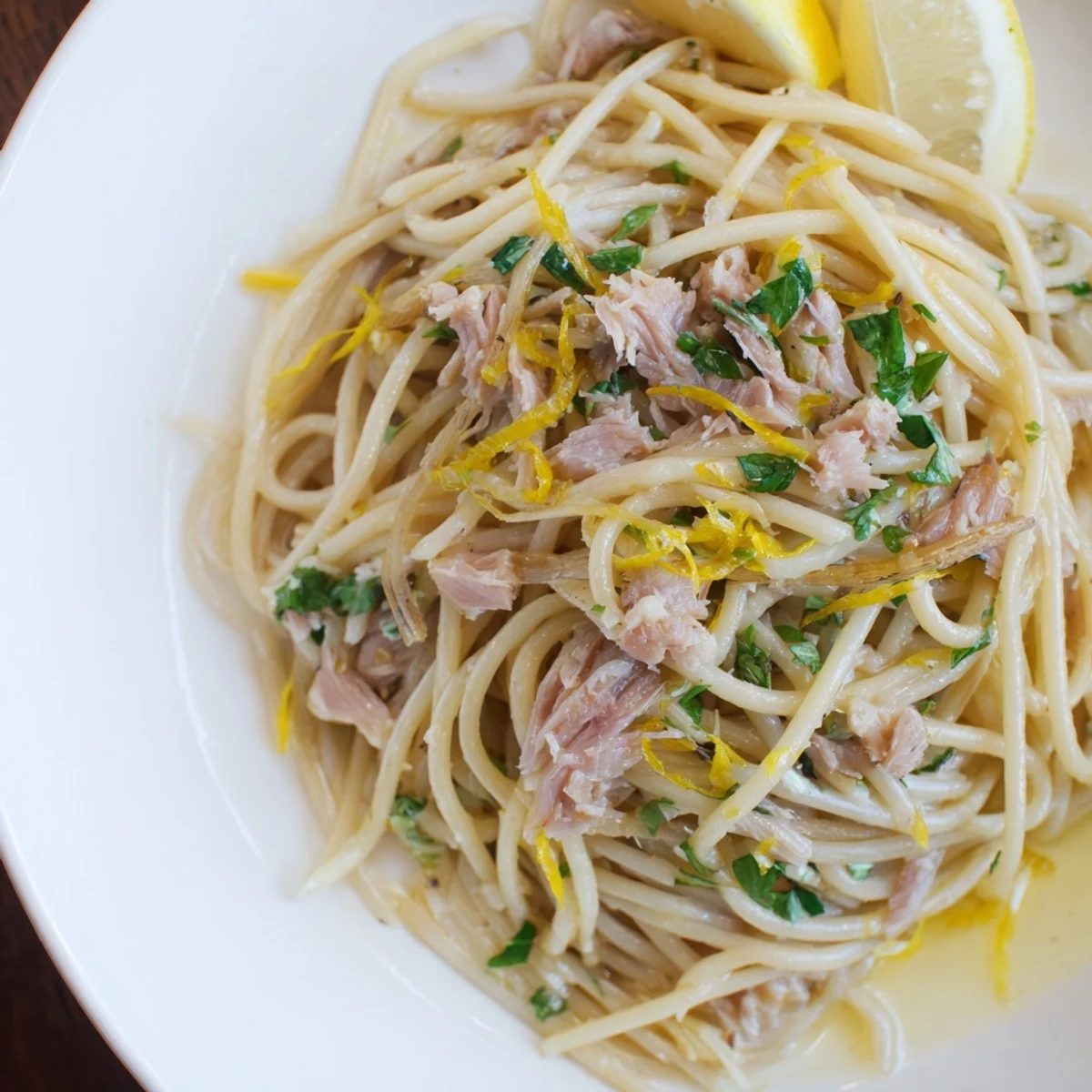 Flaky tuna over spaghetti in a zesty lemon garlic sauce, a flavorful and easy recipe.