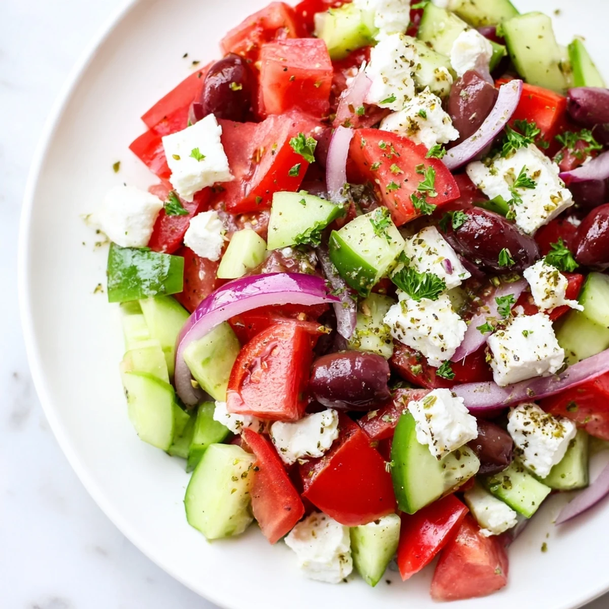 Freshly tossed Mediterranean Salad, showcasing juicy tomatoes and briny olives, drizzled with olive oil dressing.