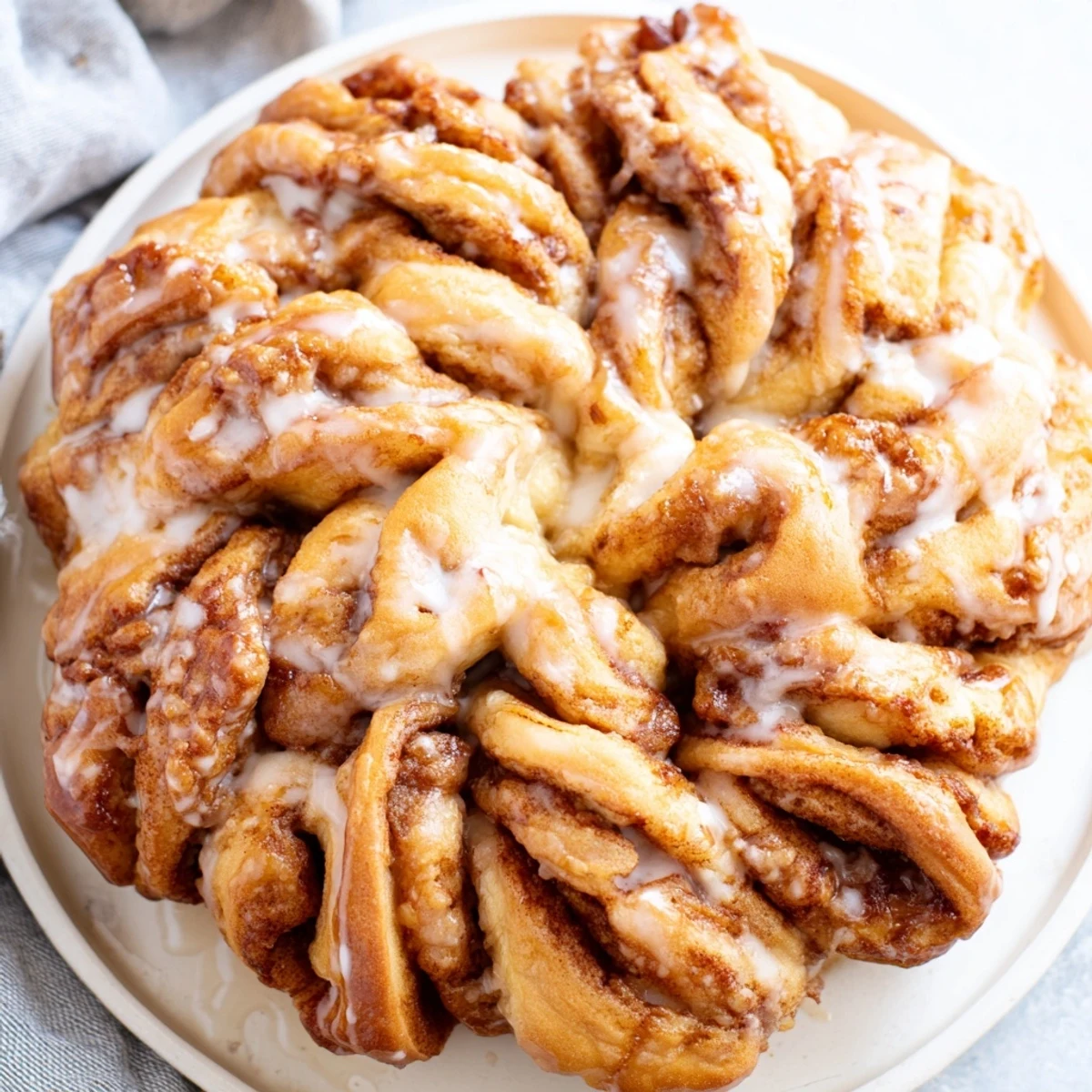 Golden brown Cinnamon Roll Pull-Apart Snowflake with sweet vanilla icing, perfect for a cozy breakfast.