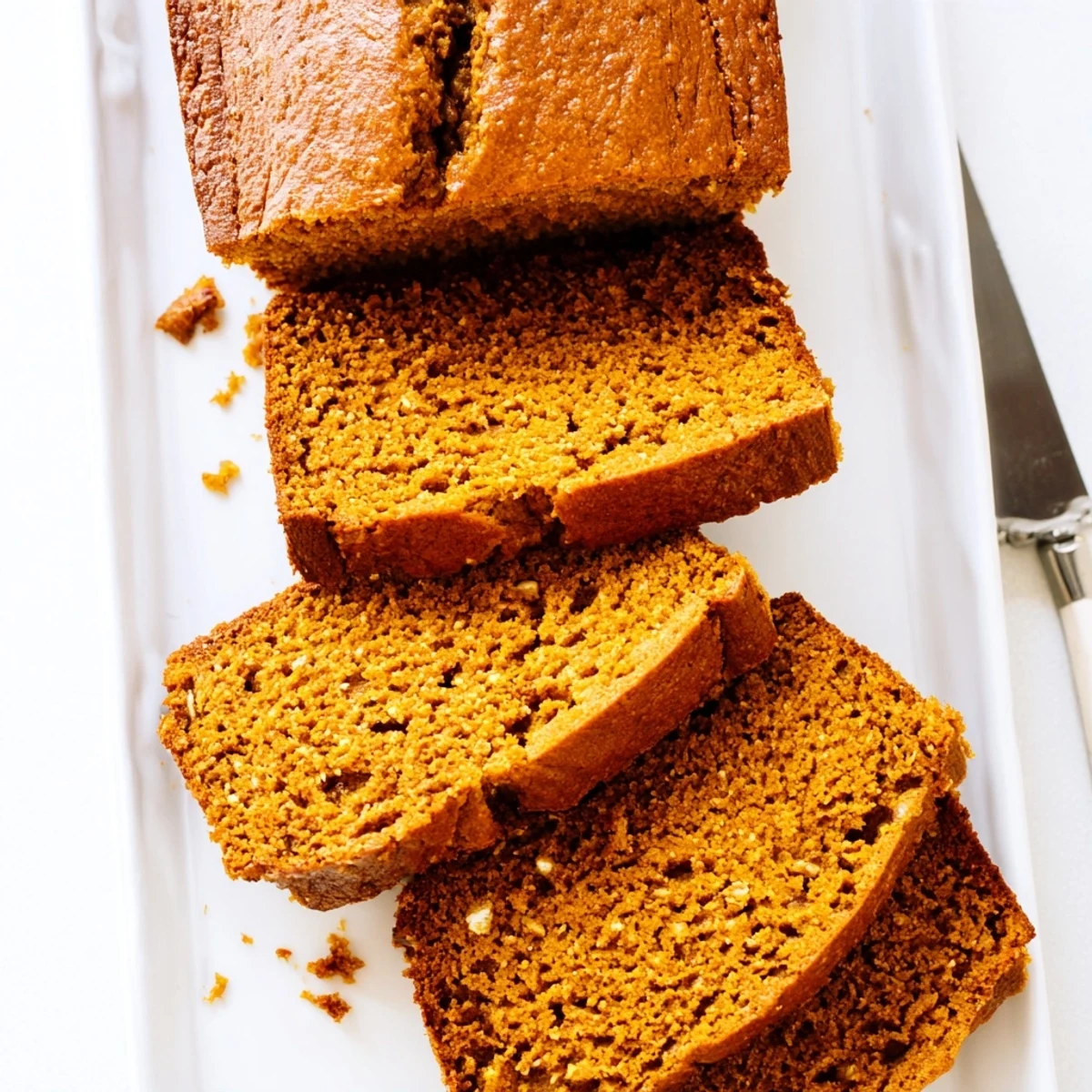 Freshly baked pumpkin bread loaf sliced on a cooling rack, perfect for breakfast or a cozy snack.