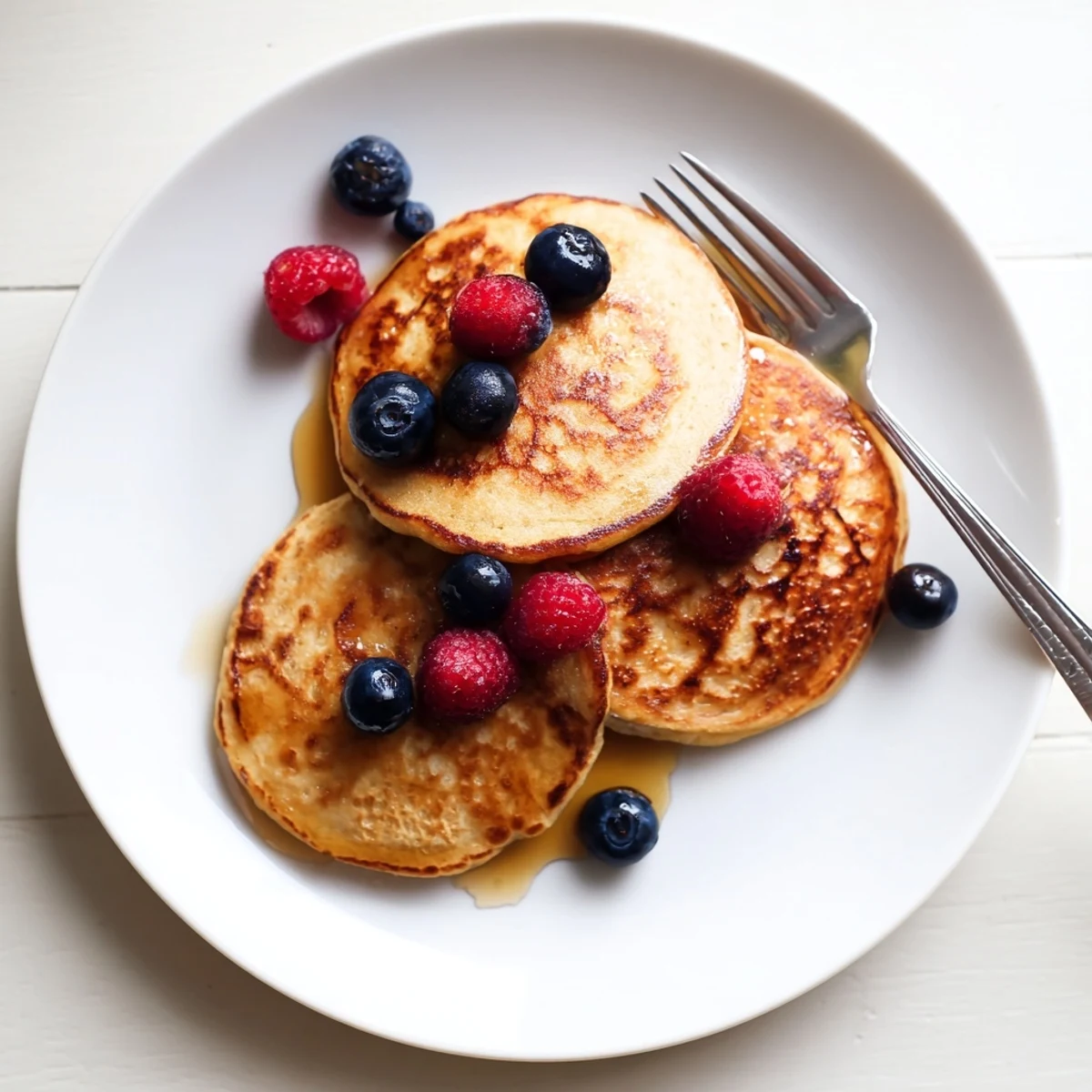 Homemade gluten-free banana pancakes served warm with a dollop of Greek yogurt and chopped nuts for a delicious snack.