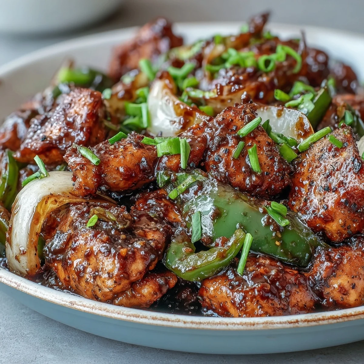 Hot skillet sizzling with Black Pepper Chicken, vibrant green bell peppers, and chopped green onions, creating an aromatic weeknight meal.