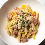 A skillet of Smoked Sausage Cajun Alfredo with penne, sausage visible amongst the creamy sauce.