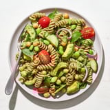 A bowlful of colorful Holiday Glow Green Goddess Protein Pasta Salad with pasta, tomatoes, and creamy dressing.