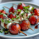 Mini Caprese skewers burst with fresh tomatoes, mozzarella, basil, and balsamic glaze.