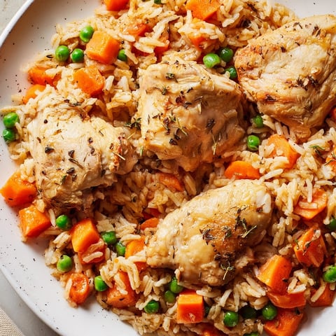 Savory One-Pot Chicken and Rice recipe: golden chicken thighs nestled in fluffy rice with peas.