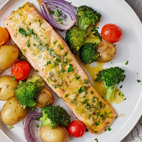 Golden sheet pan presentation of Lemon Butter Salmon, with roasted vegetables and a bright sauce.