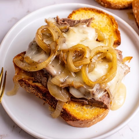 French Onion Pot Roast Casserole bubbling with melted cheese, showcasing tender beef and crusty bread.