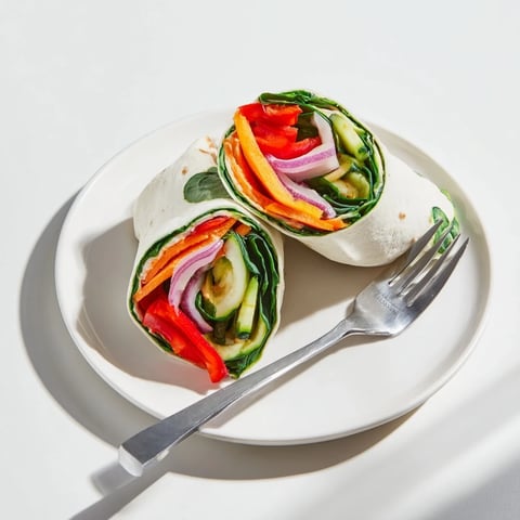 Snowflake Hummus & Roasted Veggie Wrap, featuring warm roasted vegetables ready to be folded.