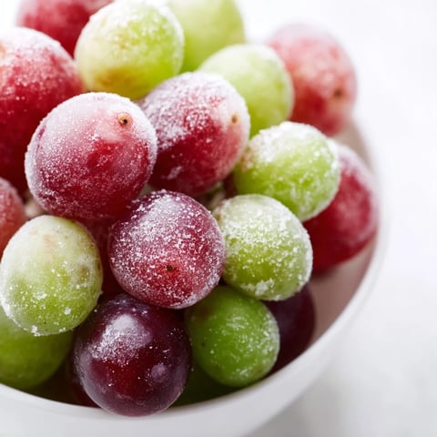 Frozen Grapes Spa Treat arranged in a chilled bowl, garnished with fresh mint, offering a crisp, juicy, and refreshing snack.  