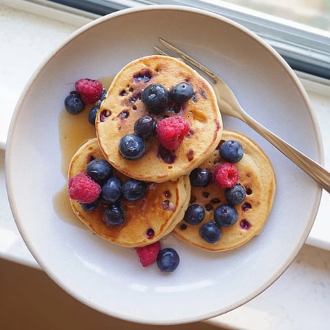 Golden-brown banana pancakes, made from mashed ripe banana and eggs, sizzling on a griddle for a healthy breakfast.
