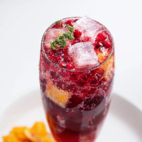 Close-up shot shows fizzy sparkling juice with raspberries and ice, perfect for a New Year's toast.