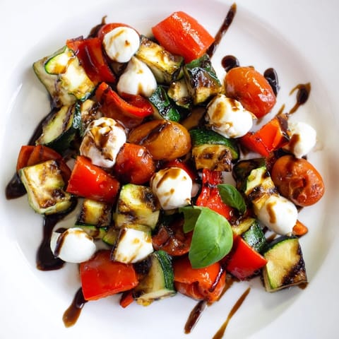 A colorful platter of caramelized Roasted Veggie Caprese Salad drizzled with sweet balsamic glaze and extra-virgin olive oil.