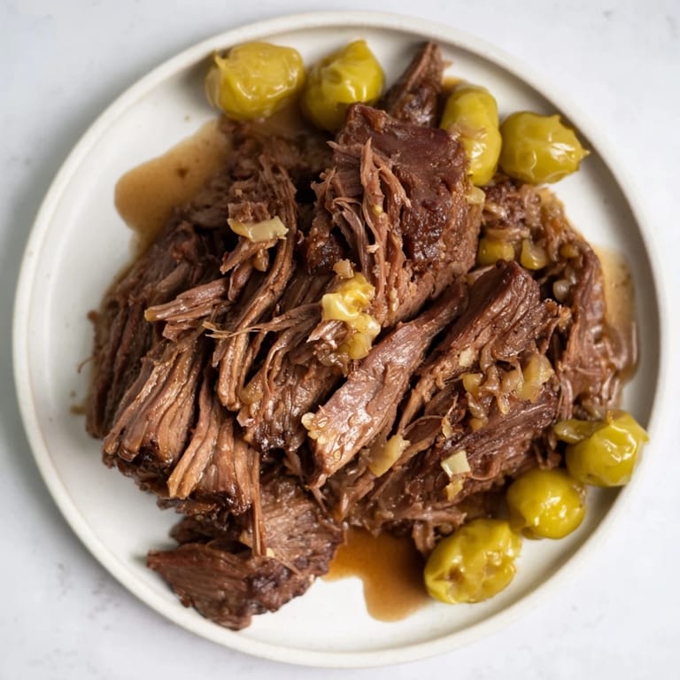 Fork-tender Slow Cooker Mississippi Pot Roast, perfect served with mashed potatoes, a classic comfort meal.