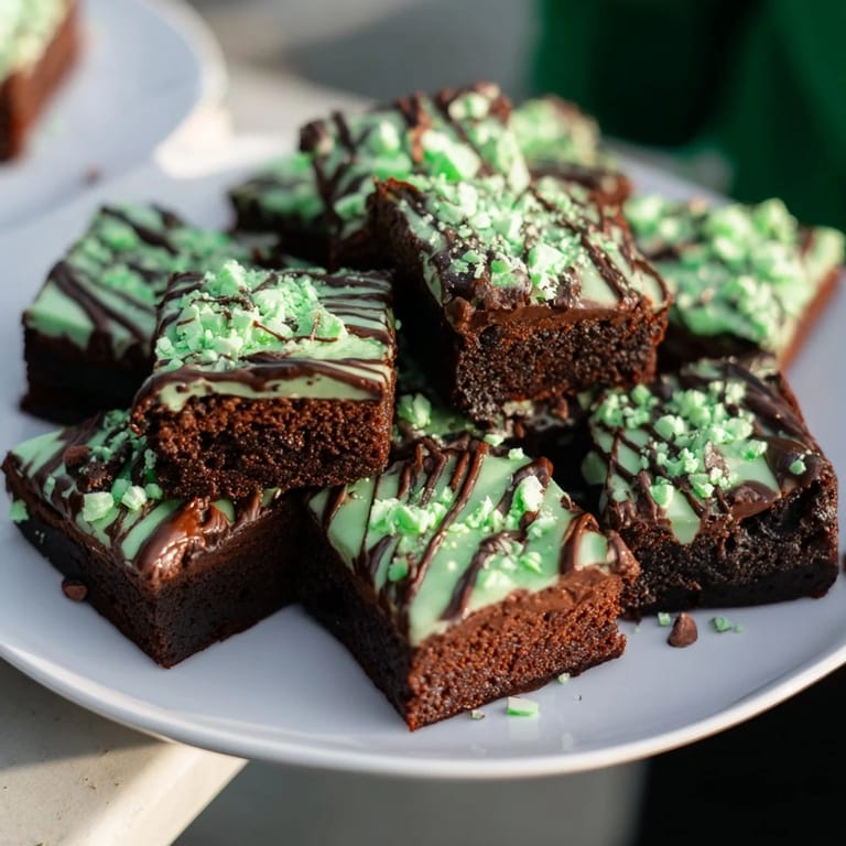 Close-up of freshly baked Peppermint Mocha Brownie Bites, rich and fudgy, with a peppermint candy garnish.