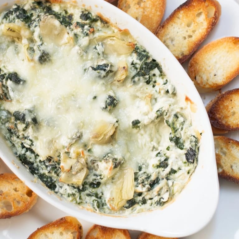 A close-up of Spinach Artichoke Dip, rich and cheesy, perfect for a cozy appetizer.