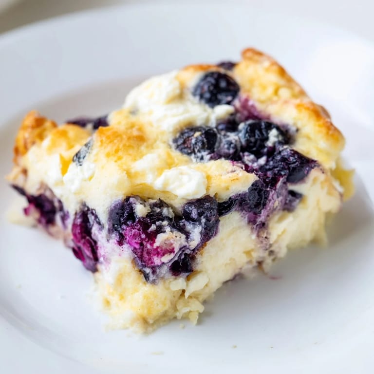 Freshly baked Blueberry Cottage Cheese Bake, featuring a bubbly top and a delicious, fruity aroma.