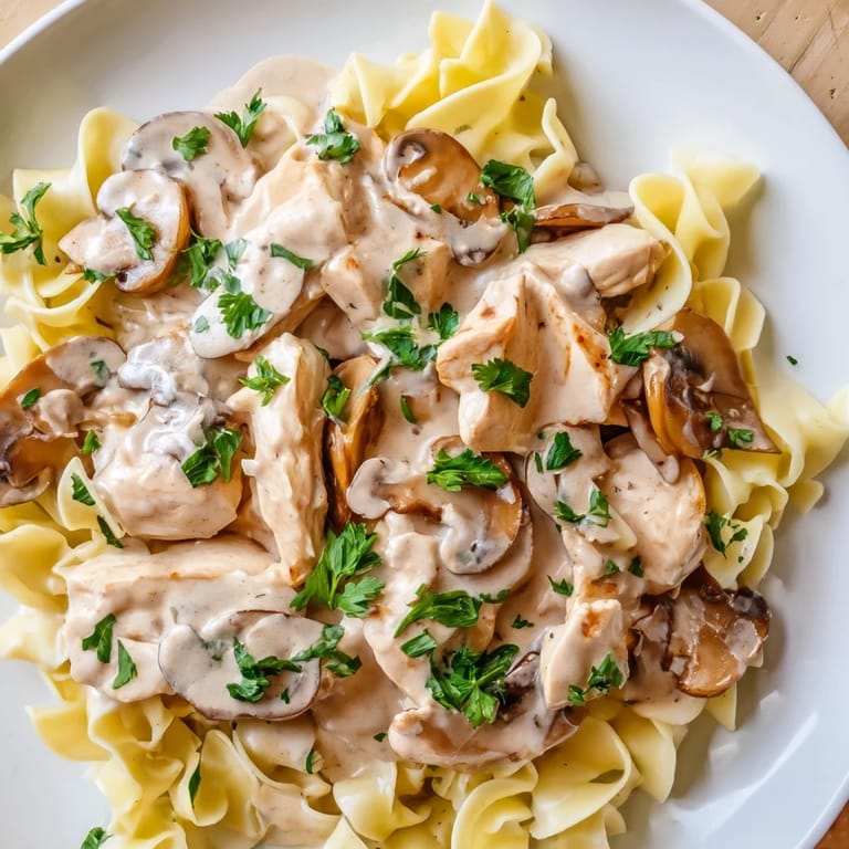 Hearty chicken strips and browned cremini mushrooms simmer in a rich, paprika-scented sauce in a skillet.