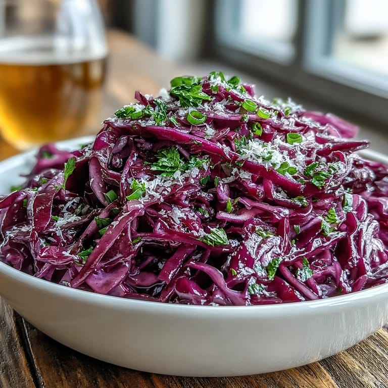 Crunchy Red Cabbage Coleslaw With Apple and Parmesan tossed in a white ceramic bowl, ready to serve as a refreshing vegetarian side dish.