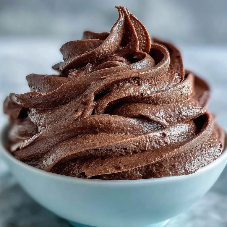 Decadent chocolate mousse filling for cakes, light and airy with swirls of whipped cream and dark chocolate shavings on top.